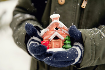 Winter little house in children's hands.