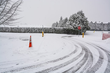 Winter tires traces on snowy road turn with stop sign in front