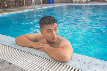 Asian man taking break after swimming
