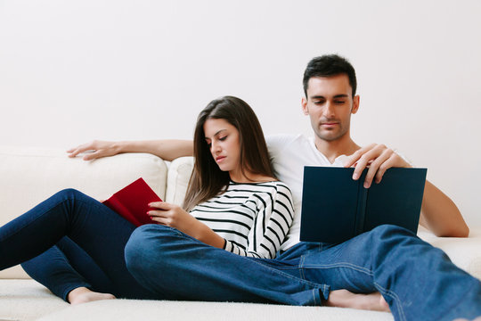 Couple Relaxing While Reading on a Sofa