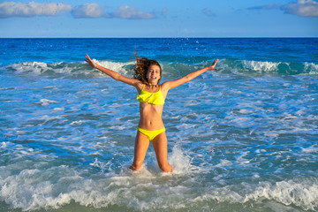 Bikini girl jumping in Caribbean sunset beach