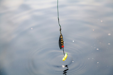 Yellow spinning spoon above surface of  water