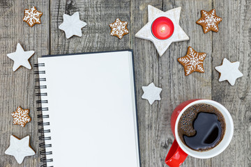 star shaped gingerbread cookies with coffee cup and notebook on grey desktop