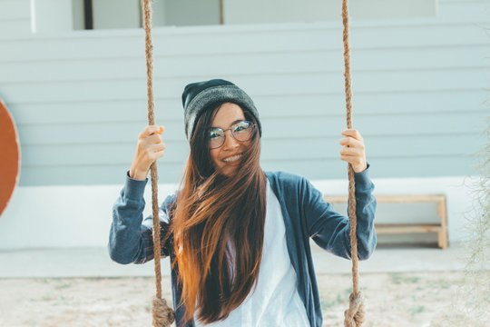 Young Asian Hipster Woman Wearing Glasses And Beanie Hat. Sitting On The Wing