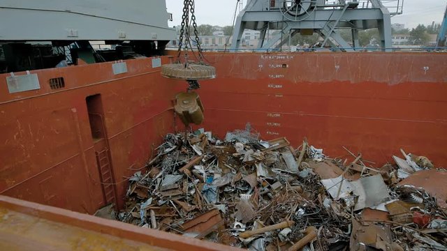 In a large container with metal debris fall iron parts, a mechanical building magnet sends the trash into a container