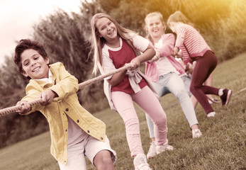Cheerful children are competing and tug of war