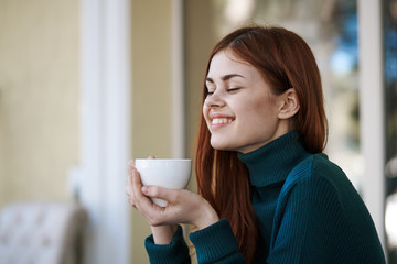 a girl in a coffee house enjoys tea