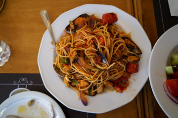 Delicious seafood spaghetti pasta with mussel, squid, shrimp, tomato sauce, etc. serve on white dish