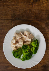 boiled chicken fillet with broccoli on wooden background. with copy space. top view