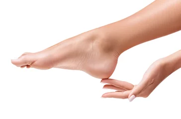 Foto op Plexiglas Perfecte vrouwelijke voeten. Hand raakt elegant been. © Dmitrii Kotin