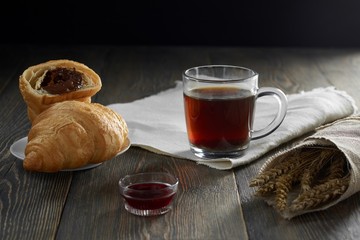 Chocolate croissants cup of tea delicious honey on the wooden table ingredients pastry recipe food breakfast eating concept copyspace.