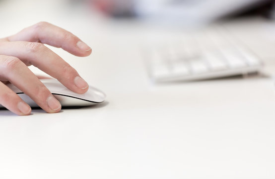 Young adult woman works on computer using mouse