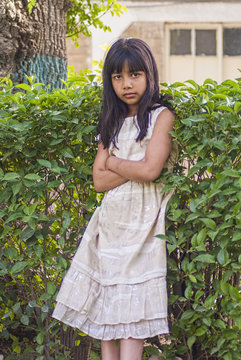 An adolescent girl standing in a serious mode.