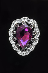 silver brooch drop with crimson stone and gems isolated on black