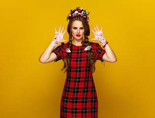 young woman in halloween costume showing bloody palms