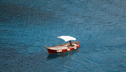 Single boat/vessel floating in fantastically blue ocean water. - 177892385