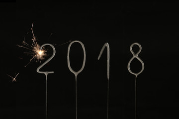 New Year's Eve celebration. 2018 made with sparklers on black background.
