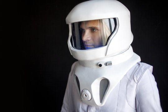 Astronaut in a helmet looks down. Fantastic space suit. Exploration of outer space.