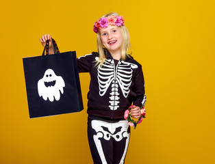 child in halloween costume isolated on yellow with shopping bag