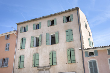 Fototapeta premium France, Provence, French Riviera, Draguignan, Lorgues: Old french house facade with open closed traditional wooden shutters painted with pastel color.