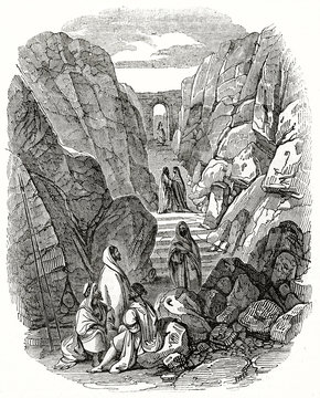 Old grayscale illustration. Ancient people walking on a stone path passing.The Ascent to Mount Sinai. Created by Leon and Laborde, published on the Penny Magazine, London, 1835