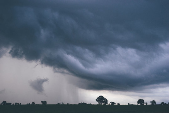 Evening thunder storm and clouds over rural scene.