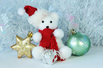 ourson polaire portant un bonnet et une écharpe rouge posé à coté de cadeaux pour décoration...
