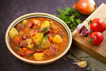 Tasty stew. Goulash soup bograch in a bowl and ingredients. Hungarian dish, horizontal