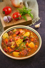 Tasty stew. Goulash soup bograch in a bowl and ingredients. Hungarian dish, vertical