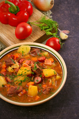 Tasty stew. Goulash soup bograch in a bowl and ingredients. Hungarian dish, vertical
