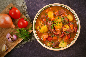 Tasty stew. Goulash soup bograch in a bowl and ingredients. Hungarian dish, view from above, top shot, horizontal © freeskyline