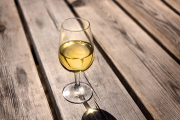 Glass of white wine on old wooden table