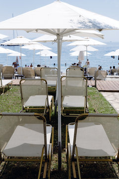 Row of white parasols leading down to a beach