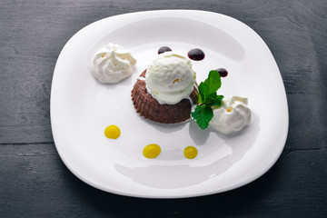 Chocolate Cake Dessert with Ice Cream. On a wooden background. Top view. Free space for your text.