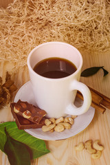 still life with hot coffee decorated with chocolate and nuts on a wooden table