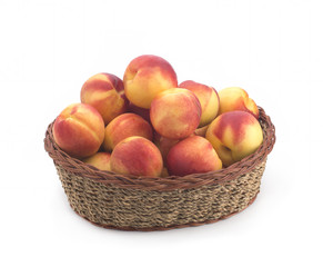 Apricots in a basket of straw on a white background