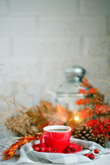 Cup of coffee, cones and autumn leaves on a wooden table. Autumn background.