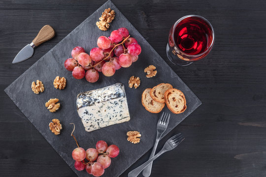 Blue cheese and grapes on black with copy space