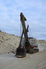 old abandoned gray digger in a sandpit