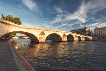 Fototapeta premium Bridge over river Seine in Paris, France at daytime viewed from a quay. Travel and architectural background. Romantic cityscape.
