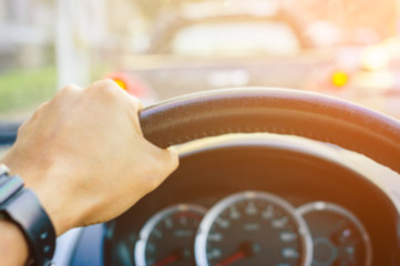 driver's hands on the steering wheel inside of a car