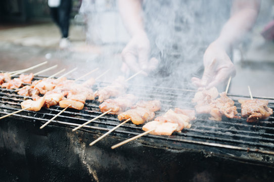 pork grill (mooping) is pork is grill with oil on a brazier in the street in the summer.The men doing pork grill.