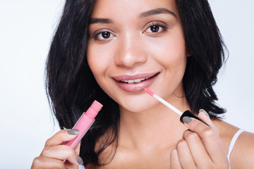 Close up of a pretty woman applying lip gloss