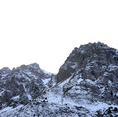 Zaili Alatau shadowed mountains against blind blue sky in winter.