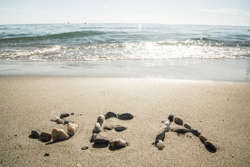 The inscription of the sea with stones on the sand with sea waves