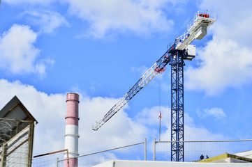 Bottom view on a crane in the sky and pipe