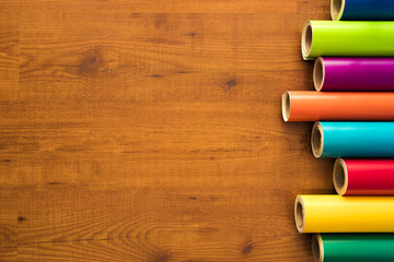 Vinilos de colores	sobre fondo de madera con sus instrumentos necesarios y cuaderno de notas