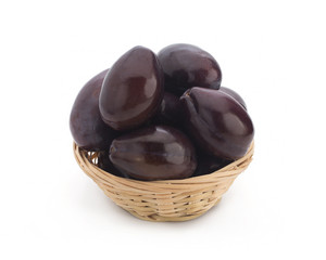 Plums. Fresh picked plums scattered from wicker basket isolated on white background