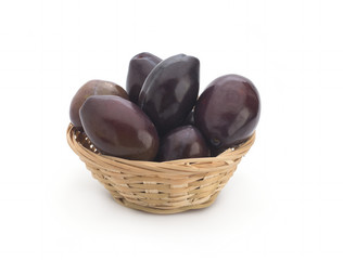 Plum in a wattled basket, isolated on a white background