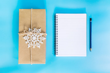 top view brown gift box and notebook paper for new year on blue pastel color.